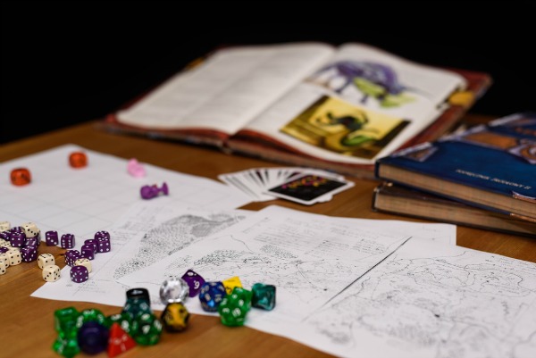 Dungeons and dragons books and dice on table.