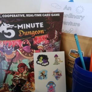 Board game, stickers, and other items in the curated family game night box.