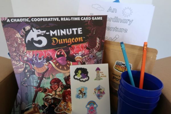 Board game, stickers, and other items in the curated family game night box.